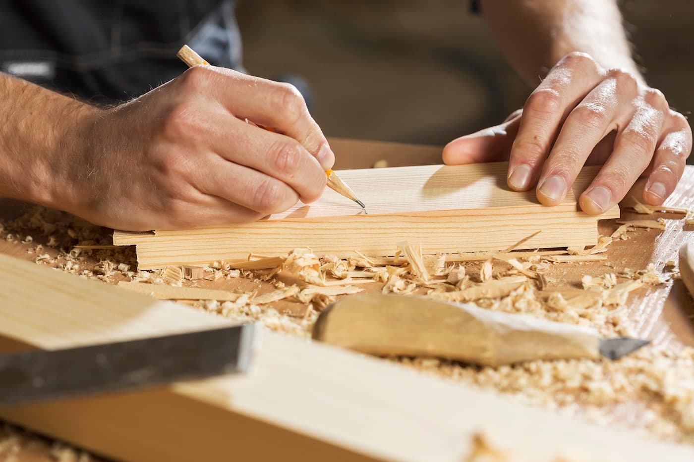 Un artisan traçant une pièce de bois à l’établi